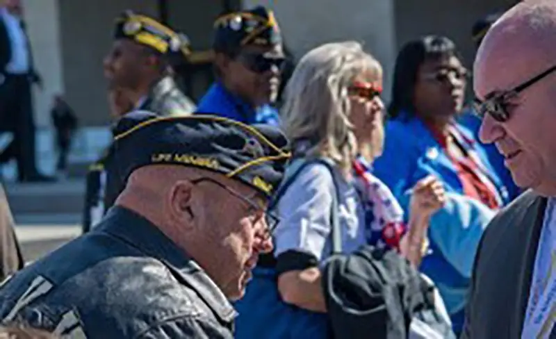 A brave veteran talking to a bald suite guy