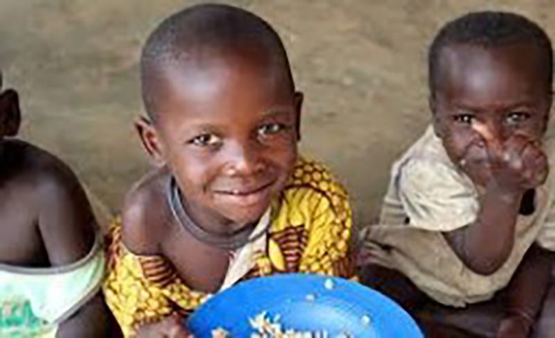 Three african kids happily eating
