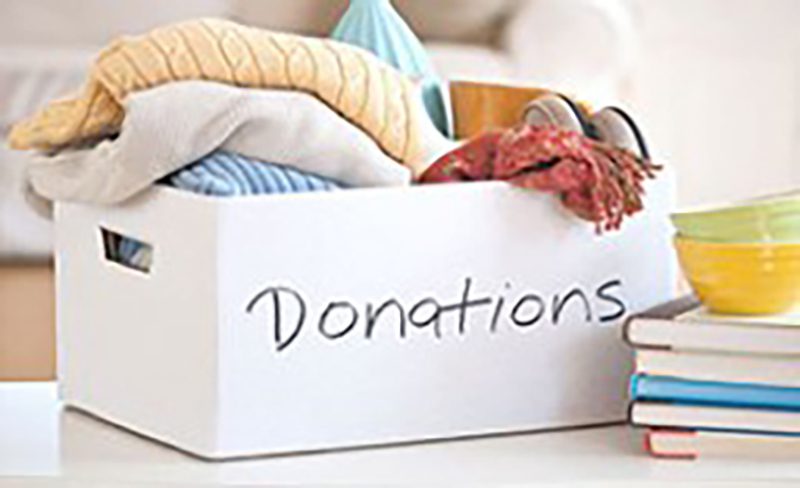 A box of donation with clothes and books inside